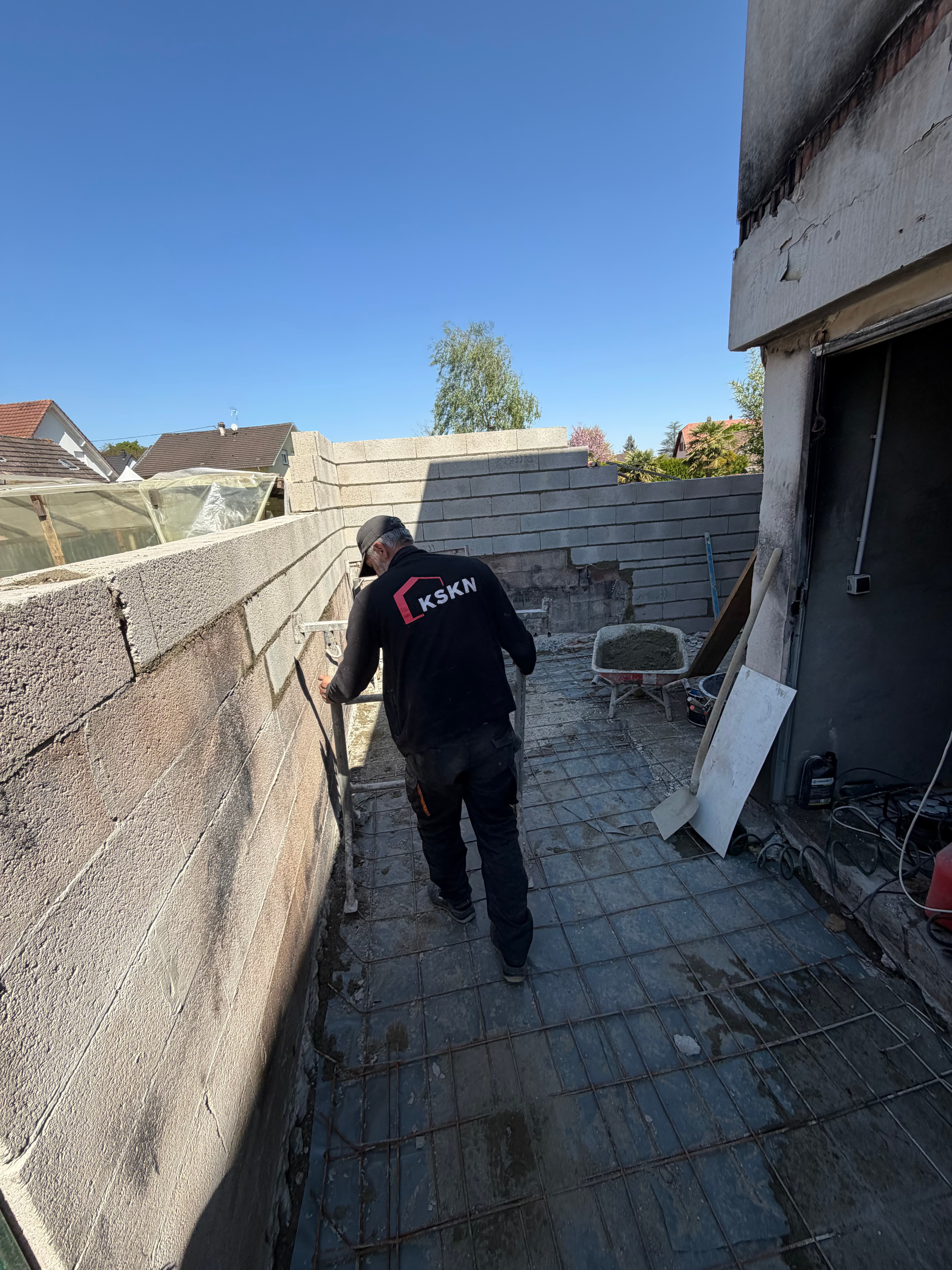 Rehausse du muret en blocs béton, ferraillage de la dalle en place au sol.