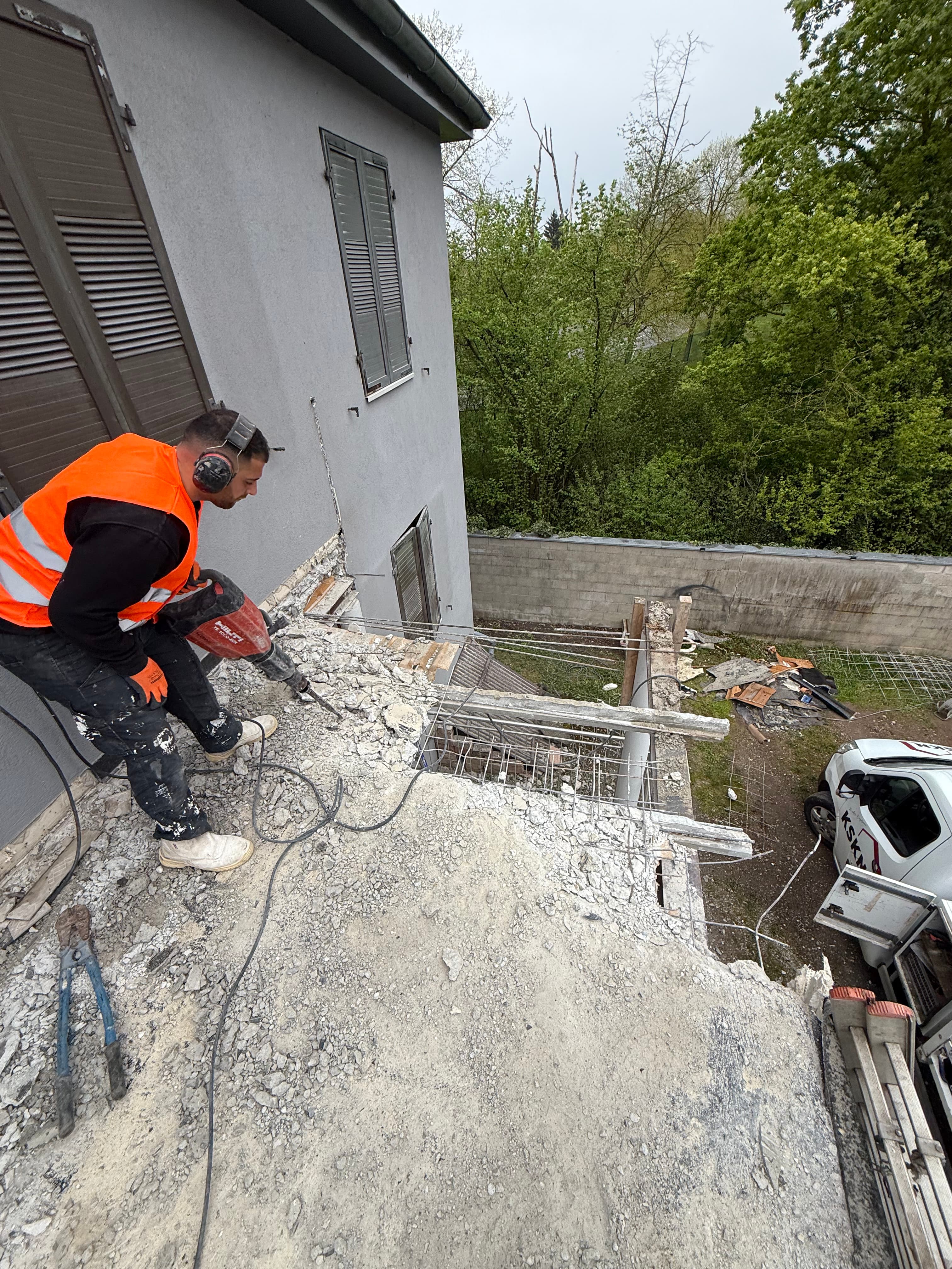 Démolition du plancher haut au marteau-piqueur, ferraillage et gravats dégagés progressivement.